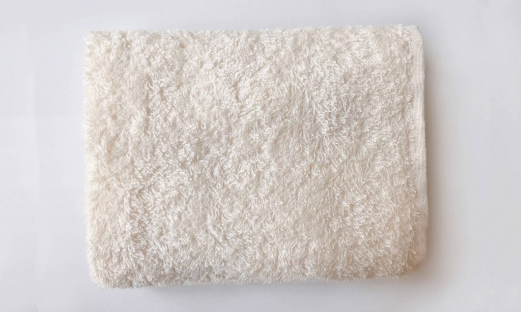タオル枕を作るにはまず、バスタオルを3つ折りもしくは4つ折りにする
