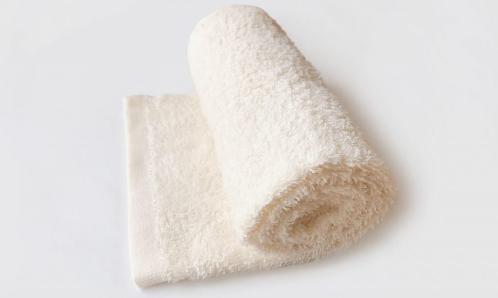タオル枕を作るには、首の高さに合うようにタオルを手前から巻くように折りたたむ